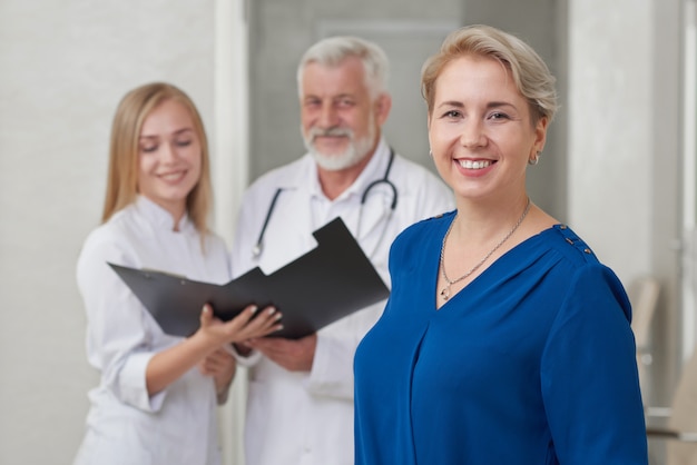 Patient heureux et médecins posant en souriant.