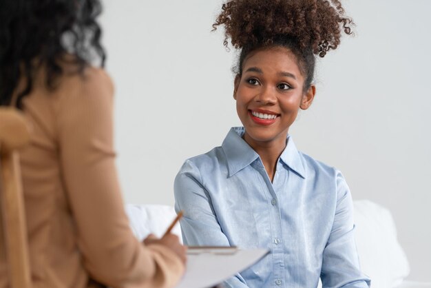 Photo un patient heureux et un psychologue ont une conversation sur la santé mentale en clinique avec une émotion positive tout en expliquant le travail et la vie cruciaux et réussis au psychologue au bureau à domicile