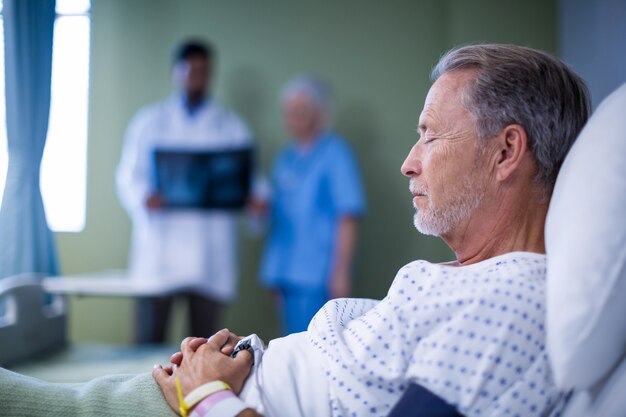 Patient malade allongé sur le lit