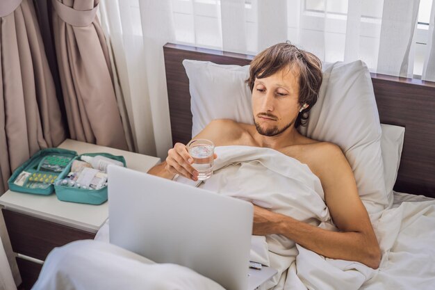 Un patient mâle est malade alors qu'il est allongé dans son lit et appelle un médecin en ligne via un gadget