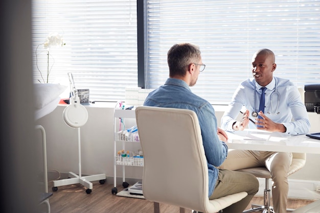 Patient mâle mature en consultation avec un médecin au bureau