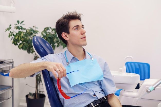 Patient masculin assis sur une chaise dentaire