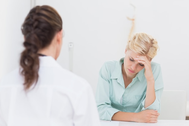 Patient avec un médecin consultant de maux de tête