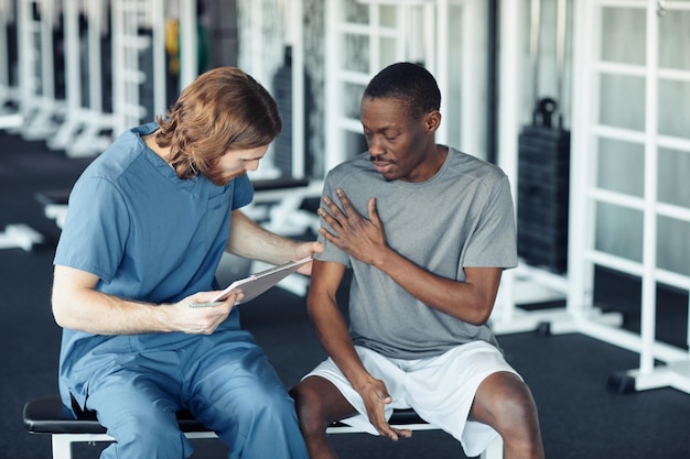 Photo patient parlant au docteur dans le gymnase