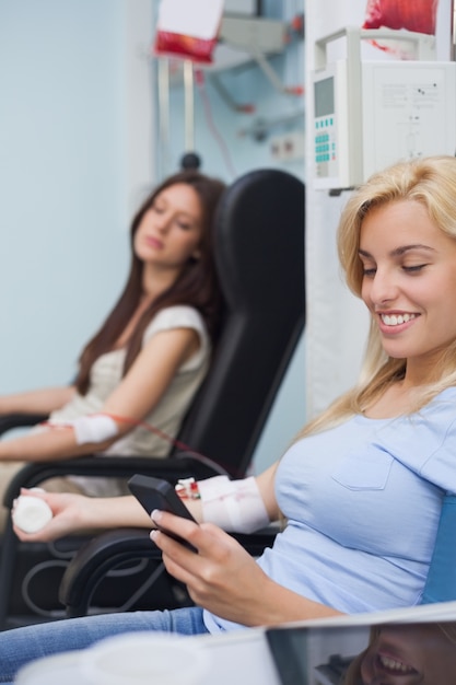 Patient recevant une transfusion en utilisant son téléphone portable