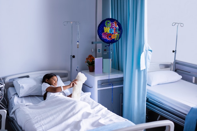 Patient reposant sur le lit avec ours en peluche