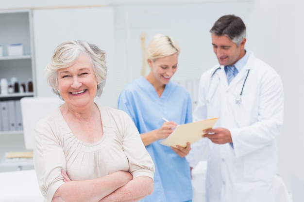 Patient souriant alors que le médecin et l'infirmière discutent dans la clinique