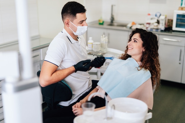 Photo patient souriant au cabinet de dentiste après le bilan