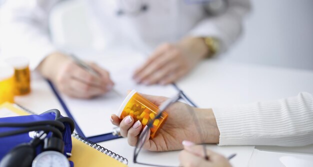 Patient tenant un pot de médicaments dans ses mains sur fond de gros plan de médecin