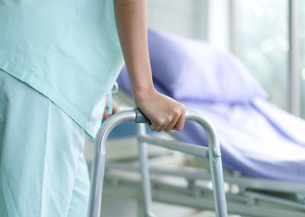 Photo le patient utilise un déambulateur après un accident et guérit à l'hôpital