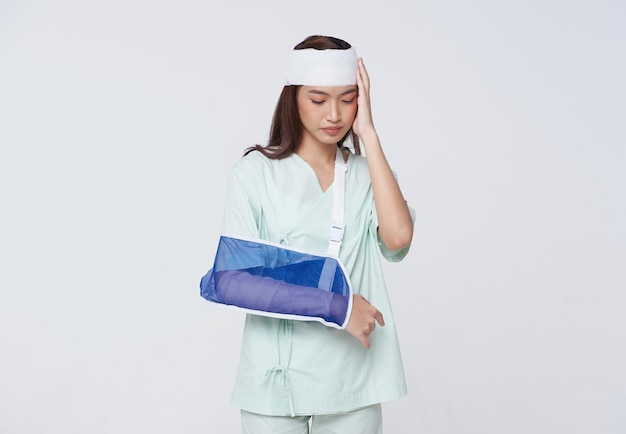 Une patiente asiatique a mis une attelle souple en raison d'un bras cassé et de maux de tête
