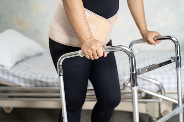 Patiente asiatique portant une ceinture de soutien pour les maux de dos.