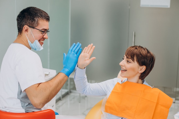 Patiente assise dans une chaise de dentiste et faisant de l'hygiène professionnelle