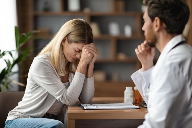 Une patiente bouleversée pleure lors d'une rencontre avec un médecin après avoir appris un mauvais diagnostic