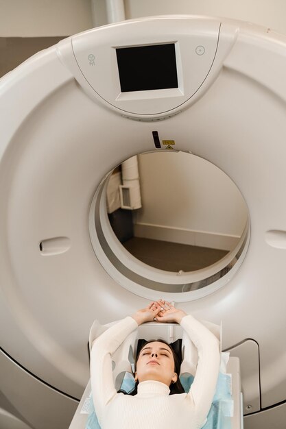 Une patiente fait une tomodensitométrie par tomodensitométrie de la poitrine pour l'examen de l'abdomen dans une salle de tomodensitométrie CT scan de l'abdomen d'une femme dans une clinique médicale