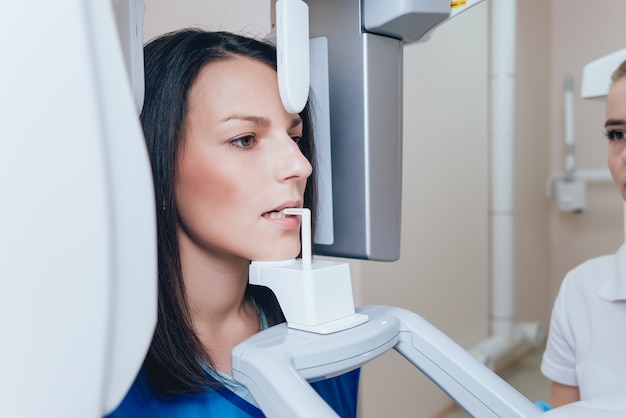 Patiente jeune femme debout dans la machine à rayons x.