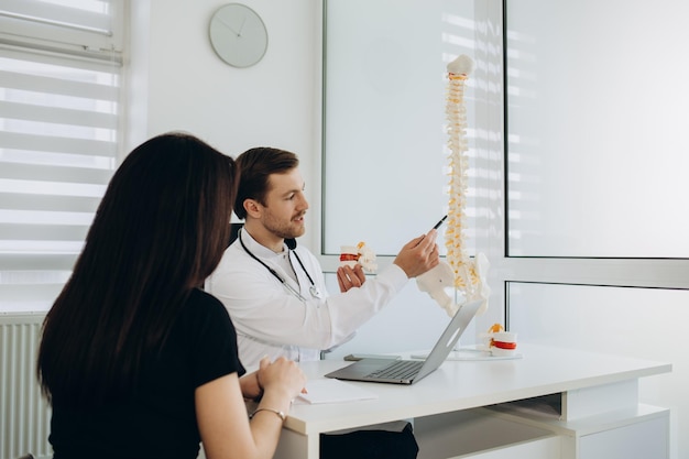 Patiente parlant au médecin de ses problèmes de dos lors d'une consultation au cabinet du médecin