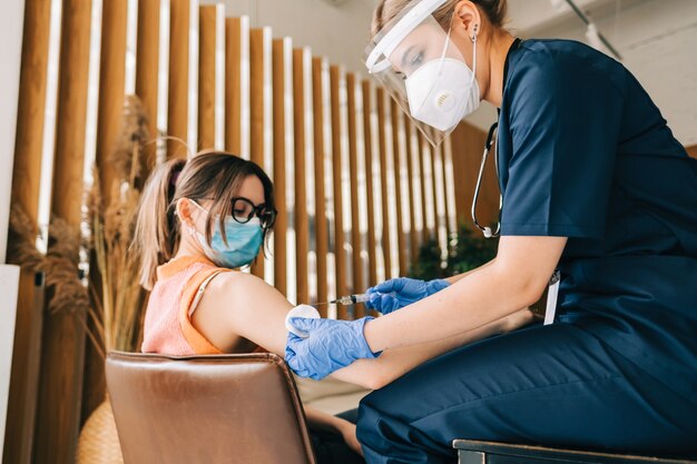 Patiente de race blanche vaccinée contre le coronavirus recevant le vaccin covid. Injection intramusculaire lors d'un rendez-vous chez le médecin à l'hôpital. Vaccination Covid-19.