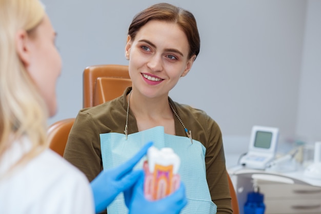 Patiente séduisante parlant à son dentiste à la clinique