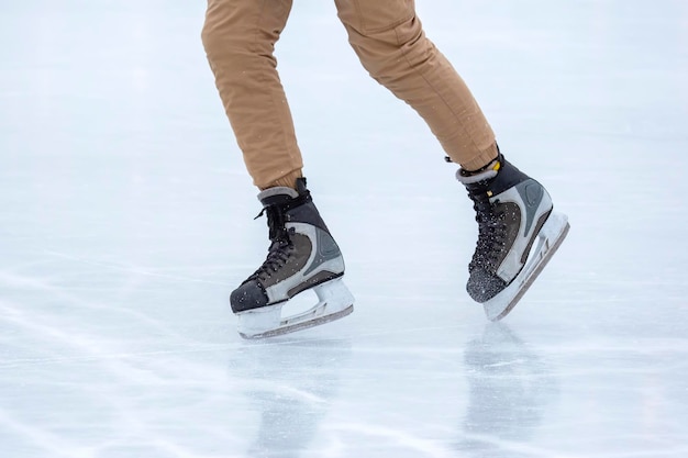 Patin à glace sur une patinoire. jambes avec patins. Passe-temps actif de sports et de loisirs d'hiver.