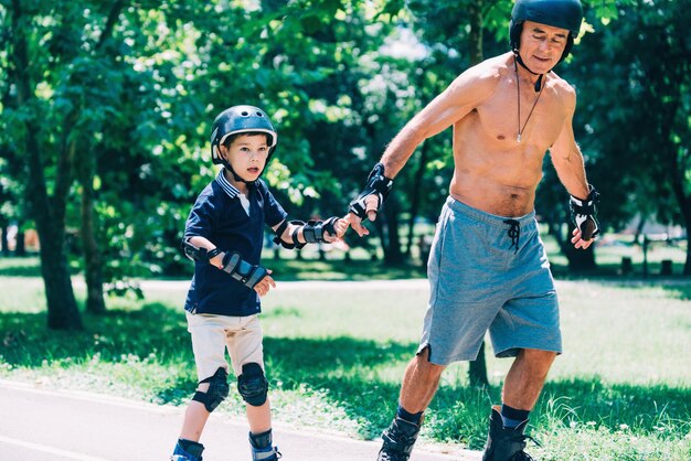 Patin à roulettes grand-père et petit-fils main dans la main