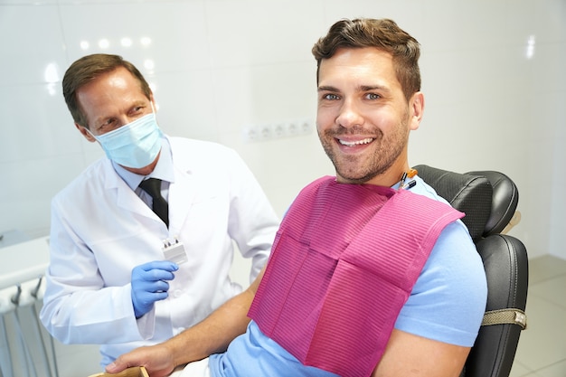 Patinet heureux de clinique dentaire lors d'un rendez-vous chez le dentiste