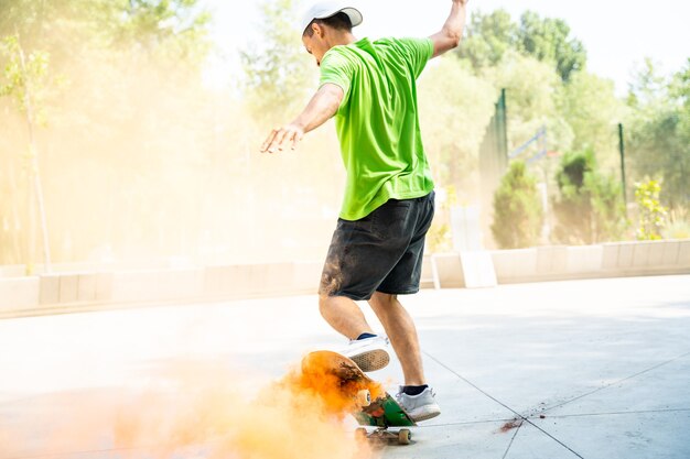Patineurs avec des bombes fumigènes colorées. Planchistes professionnels s'amusant au skate park