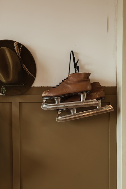 Des patins à glace et un chapeau sont accrochés au mur. Concept minimaliste hipster