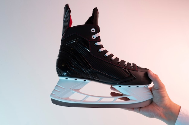 Patins à glace noirs dans les mains d'un homme