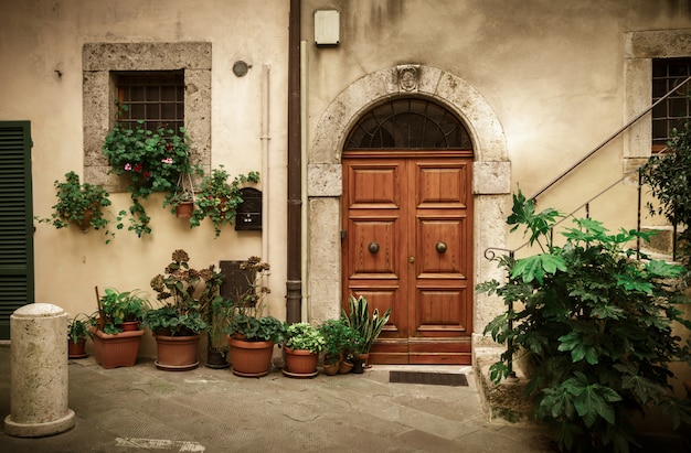 Patio italien avec porte ancienne et pots de fleurs