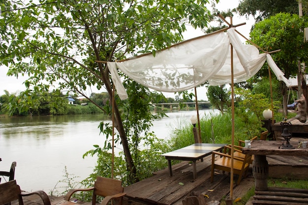 Patio-terrasse au bord de la rivière Mae Khlong ou Meklong dans un complexe hôtelier rétro vintage pour le service client en soirée à Ratchaburi Thaïlande