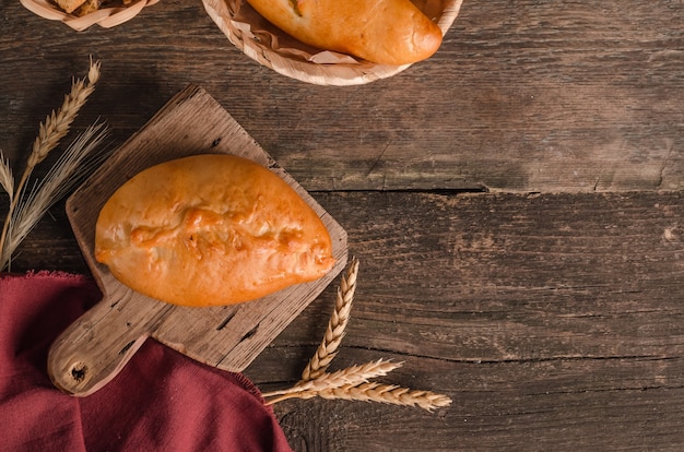 Pâtisserie culinaire fraîche appétissante remplie de galette avec espace de copie sur une planche à découper en bois et un arrière-plan