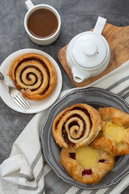 Pâtisserie danoise avec tasse de café pour le petit déjeuner. Petit pain à la cannelle.