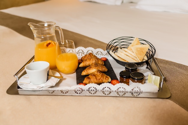 Pâtisserie fraîche avec des confitures et du jus pour le petit déjeuner