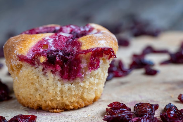 Des pâtisseries de blé avec garniture de fraise cerise rouge sur une planche de canneberges séchées séchées dans du sirop sucré traînent autour de la cuisson