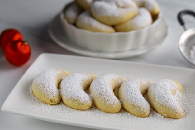 Pâtisseries de Noël allemandes croissant vanille vanillekipferl sur plaque blanche avec fond blanc