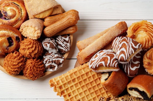 Des pâtisseries et des produits de boulangerie variés exposés sur une surface en bois pour un délicieux dessert.