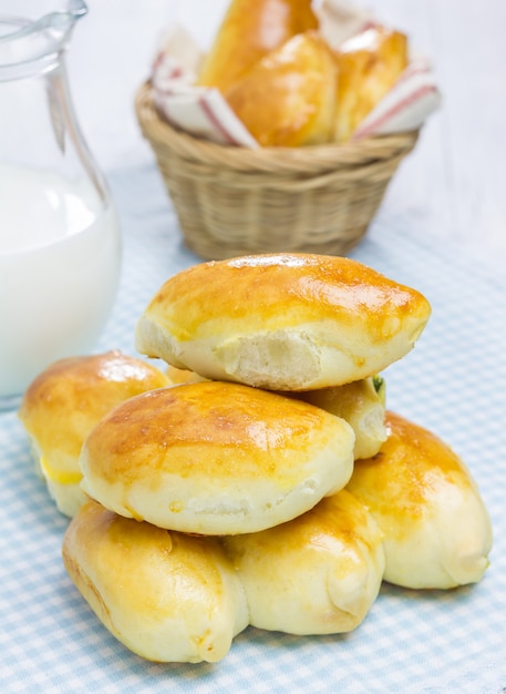 Pâtisseries russes pirogi et lait sur table en bois