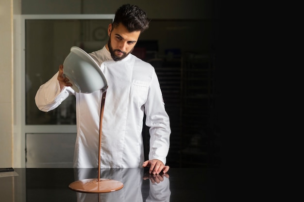 Photo pâtissier travaillant sur le tempérage du chocolat sur table en marbre