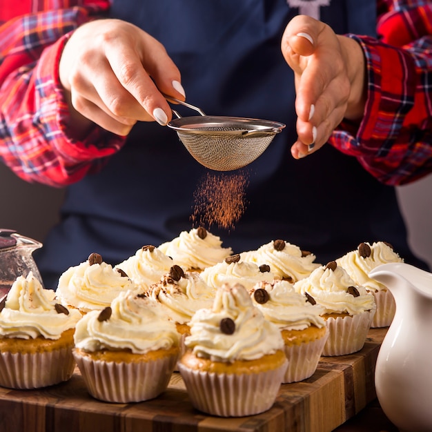 Une pâtissière décore des cupcakes