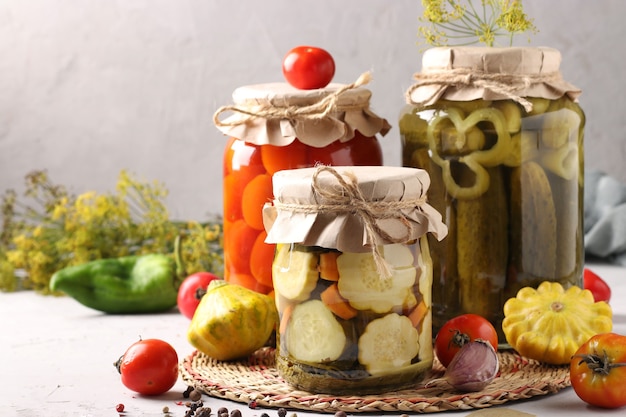 Patissons marinés maison, tomates et concombres sur gris avec des ingrédients frais