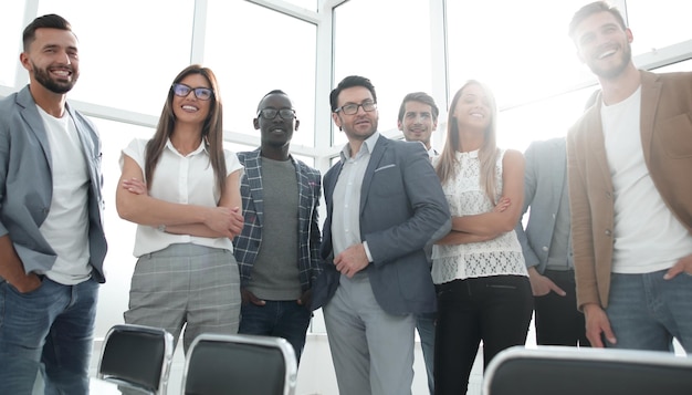 Patron et équipe commerciale debout dans un bureau lumineux