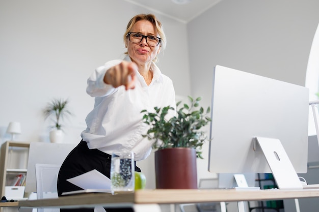 Patron féminin en colère au bureau pointant du doigt