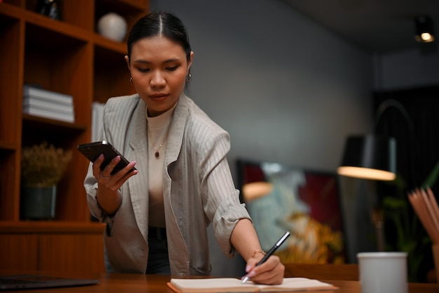 Une patronne professionnelle asiatique du millénaire concentrée sur ses tâches professionnelles