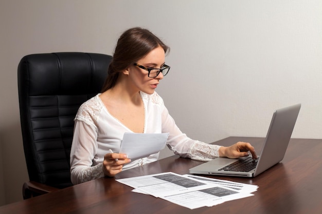 La patronne recherche des informations pour son travail d'entreprise à l'aide d'un ordinateur portable