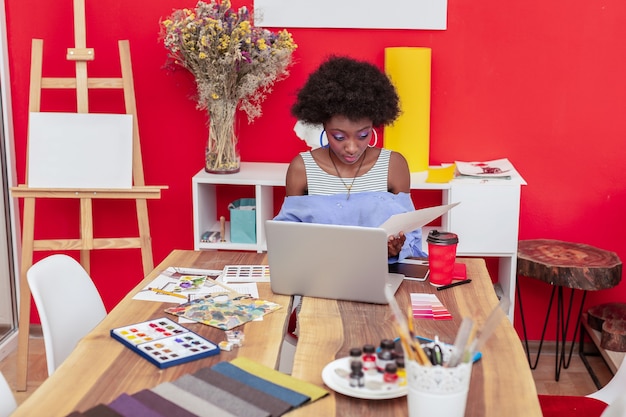 Épaules ouvertes. Designer afro-américain portant chemise avec épaules ouvertes travaillant au bureau