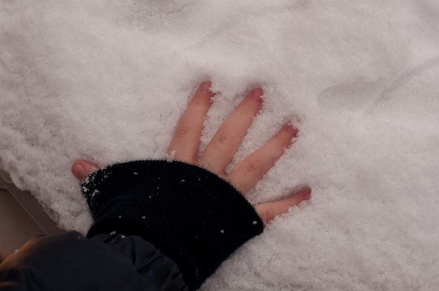 La paume d'un enfant laisse une marque sur la neige