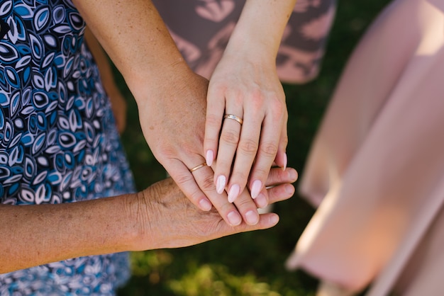 Photo la paume d'une grand-mère, mère et fille avec des anneaux de mariage. la relation entre les trois générations