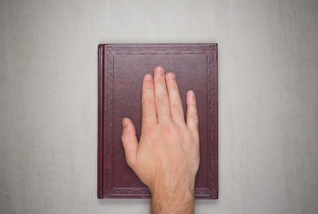 Photo la paume d'un homme sur un livre, un serment sur la bible.