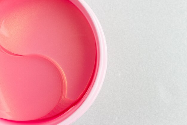 Des paupières cosmétiques hydrogel roses dans un bocal. photo en gros plan, vue de dessus